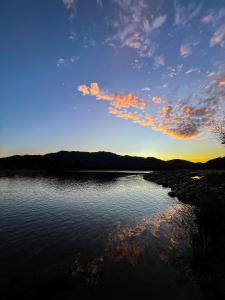 een grote hoeveelheid water met een zonsondergang op de achtergrond bij NaboCamp in Linares