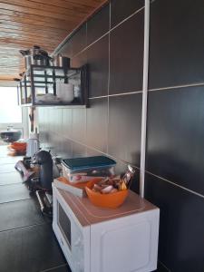 Eine Küche, in der eine Schüssel mit Essen auf einer Mikrowelle steht. in der Unterkunft Achadas da Cruz Farm House in Achadas da Cruz + 19 Fotos