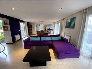 a living room with a purple couch and a table at Ostende frente al mar in Ostende +25 photos