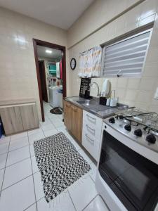 Il comprend une cuisine équipée d'une cuisinière et d'un évier. dans l'établissement Pé na areia, 4 quartos, Garagem Enorme para até 2 carros médio porte, à Balneário Camboriú