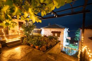 ein Haus mit Terrasse bei Nacht mit Lichtern in der Unterkunft Pelion Experience in Zagora