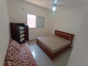 a small bedroom with a bed and a window at Aconchego em Bertioga in Bertioga