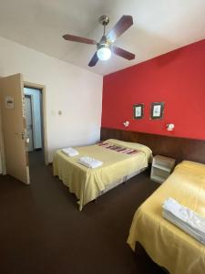 Hotel Bella Vista في فيلا جيزيل: غرفة بها سريرين ومروحة سقف