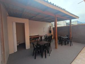 a patio with tables and chairs on a balcony at Aconchego em Bertioga in Bertioga