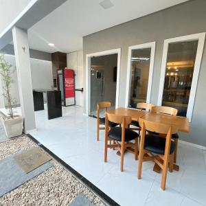 a dining room with a wooden table and chairs at Casa com 3 dormitórios na Praia do Preá com Piscina in Prea