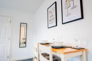 a dining room table with two chairs and a wooden table with glasses at New Street C - City Centre in Worcester +14 photos