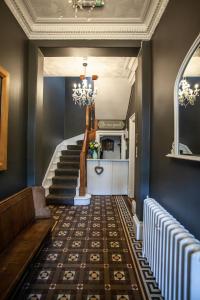 a hallway with stairs and a chandelier at The Courie Inn in Killin