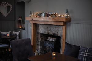 a fireplace with christmas lights on top of it at The Courie Inn in Killin