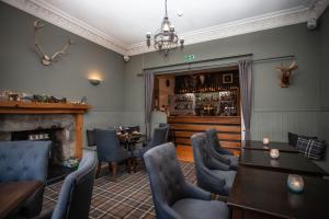 a restaurant with a fireplace and tables and chairs at The Courie Inn in Killin +6 photos