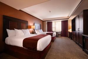 a hotel room with two beds and a television at Downstream Casino Resort in Loma Linda +39 photos