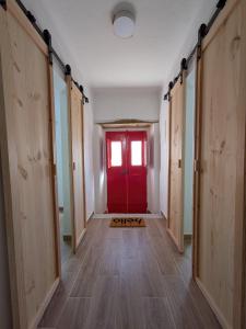 a hallway with a red door and a window at Casas da Lola - Mourão in Mourão +8 photos