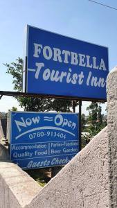 a sign for a turkish inn next to a wall at Fortbella Tourist Inn in Njara