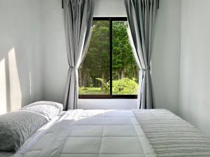 a bedroom with a bed and a window at Residencial de montaña Los Quetzales in Poás