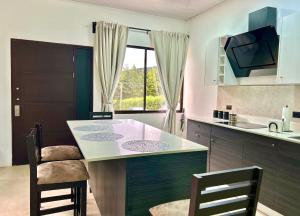 a kitchen with a table and chairs and a window at Residencial de montaña Los Quetzales in Poás