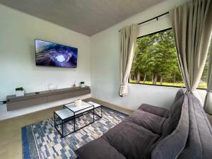 a living room with a couch and a window at Residencial de montaña Los Quetzales in Poás