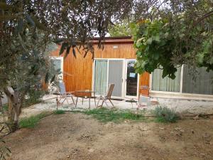 a house with two chairs and a table in front of it at Pervolaris Cottages 1 in Goudhi