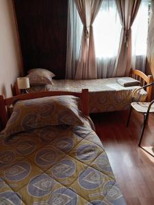 a bedroom with two beds and a window at entrre lagos Departamento in Puyehue