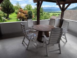 una mesa y sillas en un balcón con vistas a un campo en MaLu apartment in nature with terrace, en Jakovica