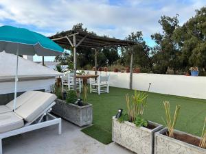 a patio with a table and chairs and an umbrella at appartement Topaze in Essaouira