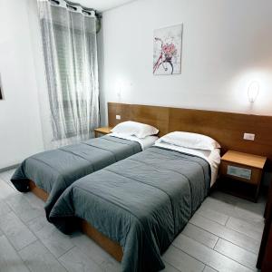 Dos camas en una habitación de hotel con aire acondicionado. en La Fenice Hotel, en Reggello