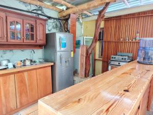 Homestay Natural Paradise habitación 3 في سان كريستوبال: مطبخ مع كونتر خشبي علوي وثلاجة