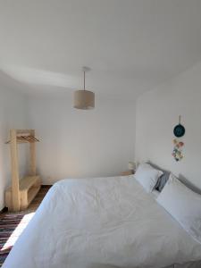 a white bedroom with a large bed with a white comforter at Casas da Lola - Mourão in Mourão