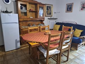 a kitchen with a table and a white refrigerator at apartment Ravelli in Piano