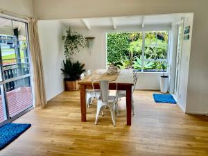 a dining room with a wooden table and chairs at Tairua Tides - Relaxed Coastal Retreat in Tairua
