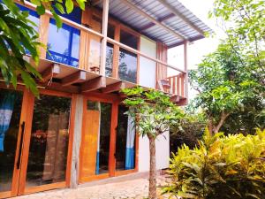 Homestay Natural Paradise habitación 3 في سان كريستوبال: منزل به نوافذ زجاجية وشجرة