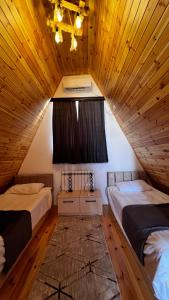 Dos camas en una habitación con techos de madera. en A-frame evlər, en Qusar