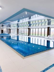 a large building with a swimming pool in the middle at Navy Blue Dream - SPA - Basen - Parking in Dziwnów