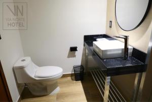a bathroom with a white toilet and a sink at Hotel Vía Norte in Tuxtla Gutiérrez