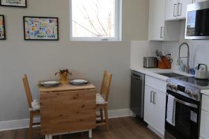 a kitchen with white cabinets and a table with plates on it at Charming Carriage House in NE Washington DC in Washington