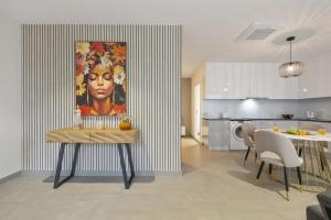 a kitchen and dining room with a painting of a woman at Sunflower Gem by Homie in Caniço