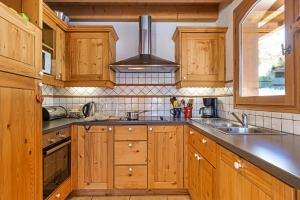 een keuken met houten kasten en een spoelbak bij Chalets d'en haut - Bonheur - Happy Rentals in Chamonix-Mont-Blanc