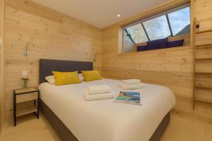 een slaapkamer met een groot wit bed met gele kussens bij Chalets d'en haut - Bonheur - Happy Rentals in Chamonix-Mont-Blanc