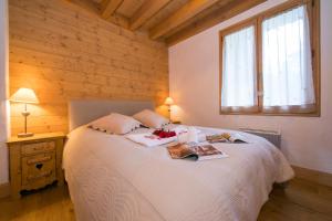 een slaapkamer met een wit bed met een houten wand bij Chalets d'en haut - Bonheur - Happy Rentals in Chamonix-Mont-Blanc