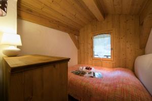 een slaapkamer met een bed in een houten kamer bij Chalets d'en haut - Bonheur - Happy Rentals in Chamonix-Mont-Blanc +36 foto's