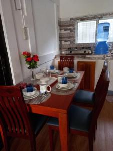 a dining room table with chairs and a wooden table with roses at Hill View Home Stay Bohol in Panglao