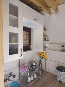 a kitchen with white walls and a table with flowers at Planinska kuca-Jovanovic! in Kremna