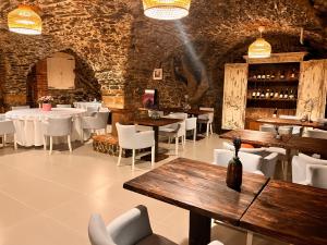 a restaurant with wooden tables and white chairs and a bar at Nowa Prowansja in Chrośnica