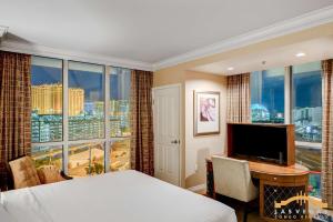 a bedroom with a bed and a desk and a large window at MGM Signature-09-821 1Br2Ba F1 Strip View Balcony Suite in Las Vegas