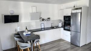 a kitchen with a refrigerator and a table with chairs at VisitAylinVis in Vis