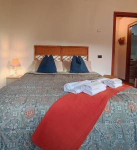 a bed with blue pillows and towels on it at Torre Cà Emo, CasAmarti in Vittorio Veneto