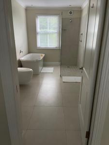 bagno con vasca, servizi igienici e finestra di Airlie Well a Constantia Altre 3 foto