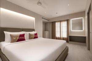 a bedroom with a large white bed with two pillows at Aceotel Premier Ujjayanta, Ujjain in Ujjain +12 photos