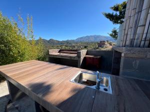 a kitchen sink on a wooden table with a view at Punta El Tesoro - Playa Privada al Lago in Potrero de los Funes