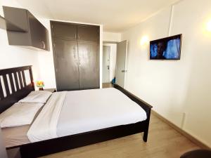 a bedroom with two beds and a tv on the wall at Casa de la Mama in Parque Holandes