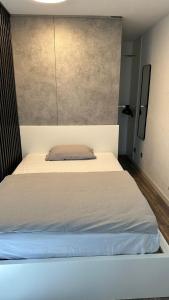 una camera da letto con un letto grande con un copriletto bianco di Casa Verona a Landstuhl