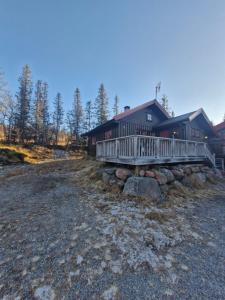 una grande casa con un portico e delle rocce davanti di Fjellvang a Haglebu